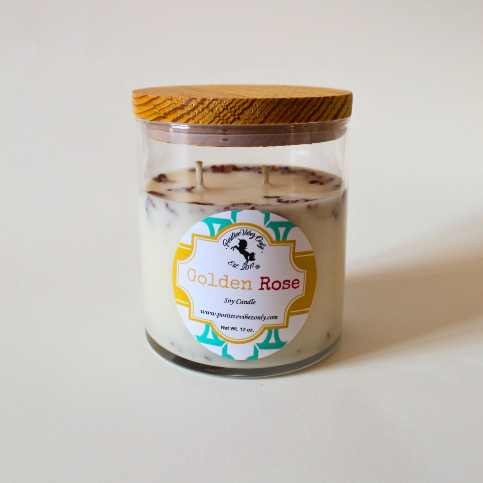 Glass candle jar with a wooden lid and 'Golden Rose' label on a white background